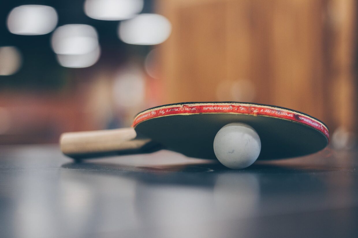 selective focus photo of table tennis ball and ping pong racket